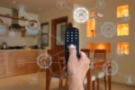 Pessoa controlando automação residencial com controle remoto em cozinha moderna