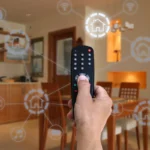 Pessoa controlando automação residencial com controle remoto em cozinha moderna