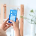 Pessoa controlando dispositivos de casa inteligente por app em 2025