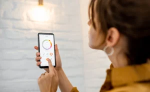 Mulher usando aplicativo de automação residencial no celular para controlar luzes